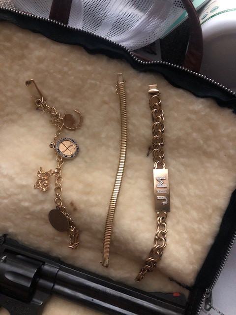Three pieces of jewelry displayed in a padded pouch